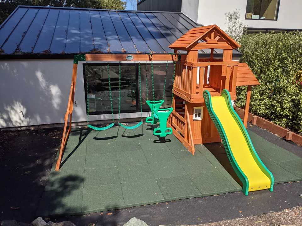 Backyard Discovery wooden playset with roofed tower, slide, swings and glider, assembled by Artem