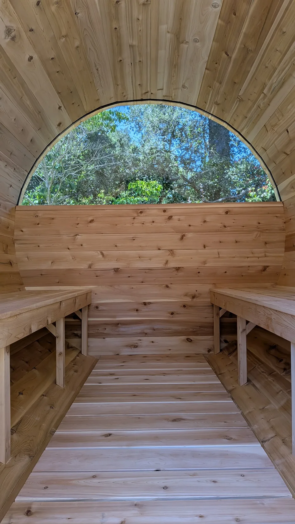 Wooden benches and curved interior of a barrel sauna assembled by Artem