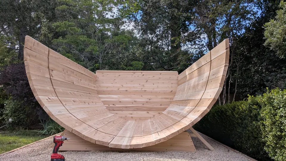 The curved wooden shell of a barrel sauna during assembly
