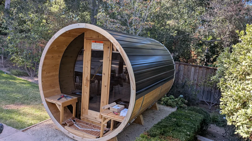 Completed dark roof on a wooden barrel sauna